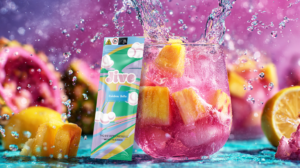 A vibrant image showing a fruity pink drink with splashes, tropical fruits, and THC vape packaging labeled “Jive – Rainbow Belts.”