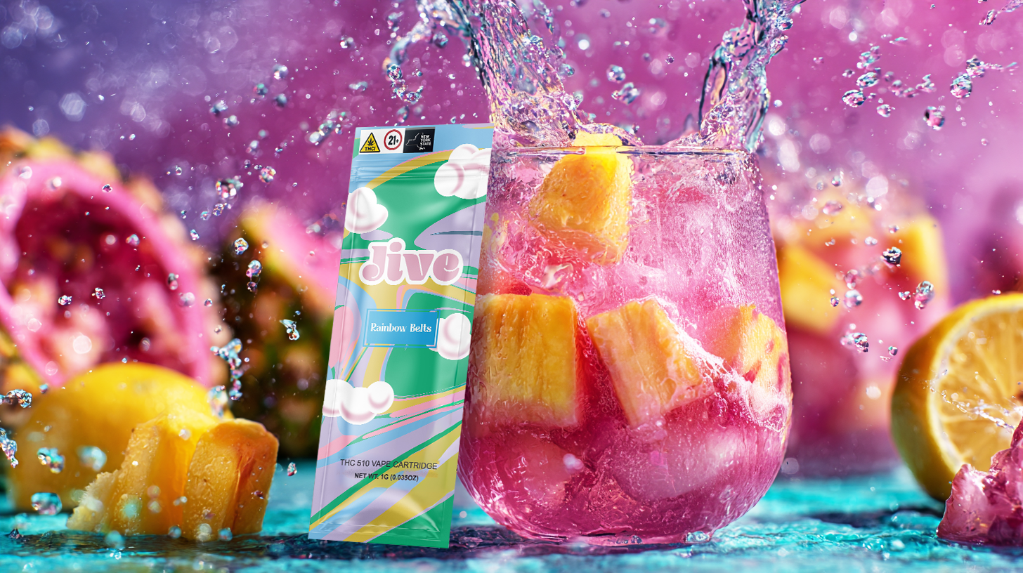 A vibrant image showing a fruity pink drink with splashes, tropical fruits, and THC vape packaging labeled “Jive – Rainbow Belts.”