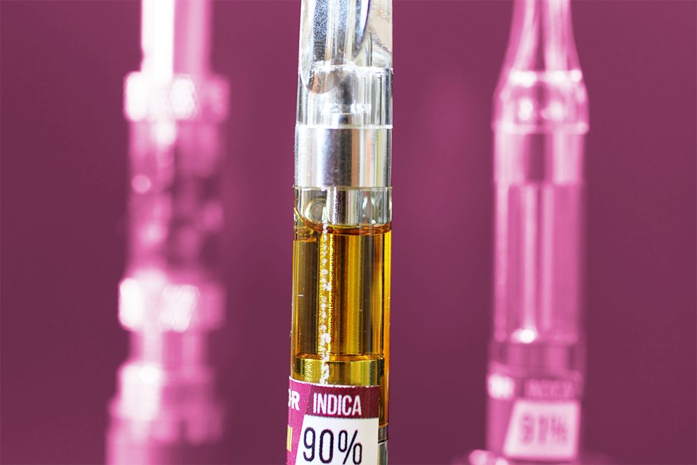 High-potency cannabis vape cartridge labeled as 90% THC Indica against a pink-purple background.