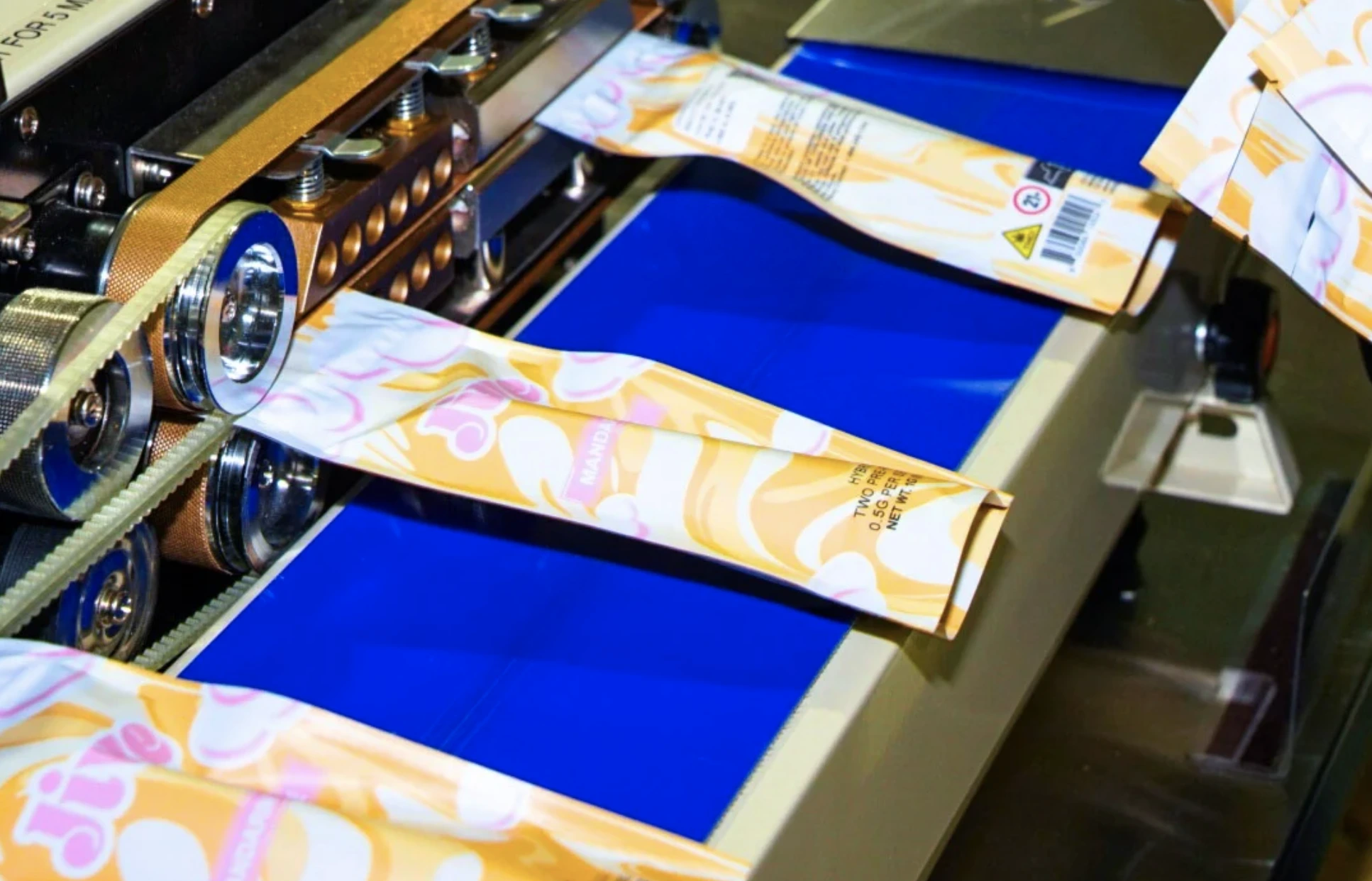 Jive-branded cannabis vape product packages moving through an automated assembly machine.